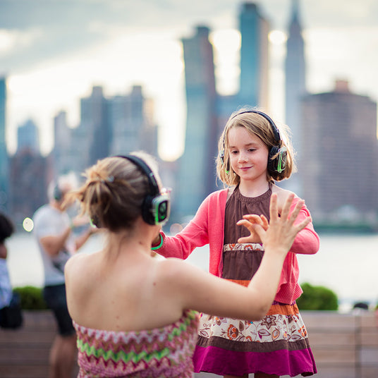 Quiet Events Silent Disco headphones for all ages. A mother and daughter having fun outdoors with headphones.