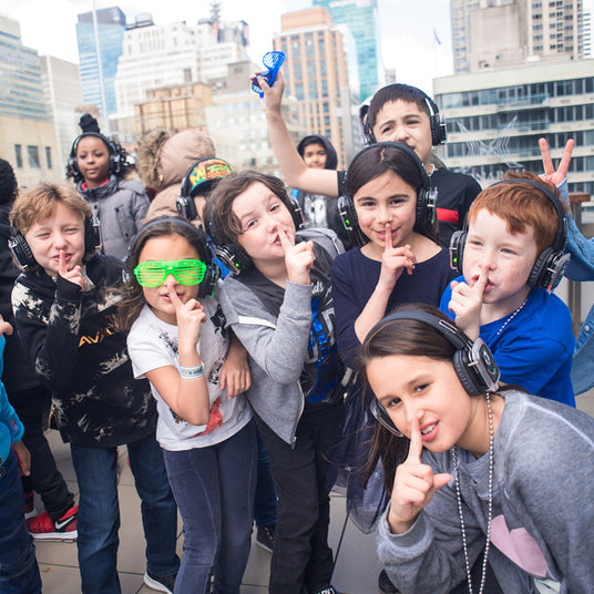 Quiet Events Silent Disco headphones for church. A group of kids outdoors having fun wearing headphones.
