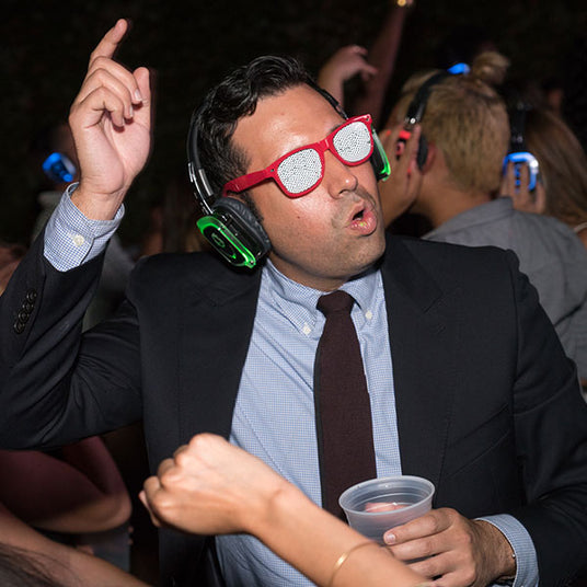 Quiet Events Silent Disco headphones for dance parties a corporate man with party glasses having fun with headphones.