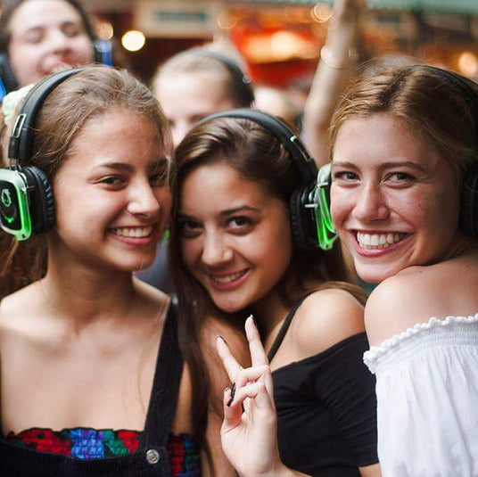 Quiet Events Silent Disco headphones for dance parties a group of young girls smiling and having fun with headphones.