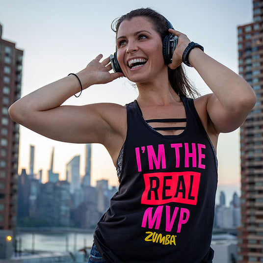 Quiet Events Silent Disco headphones for fitness and meditation. A zumba instructor having fun outdoors holding her headphones.