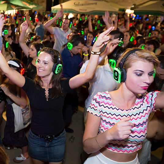 Quiet Events Silent Disco headphones for public spaces a group of people at an open place dancing and having fun with headphones