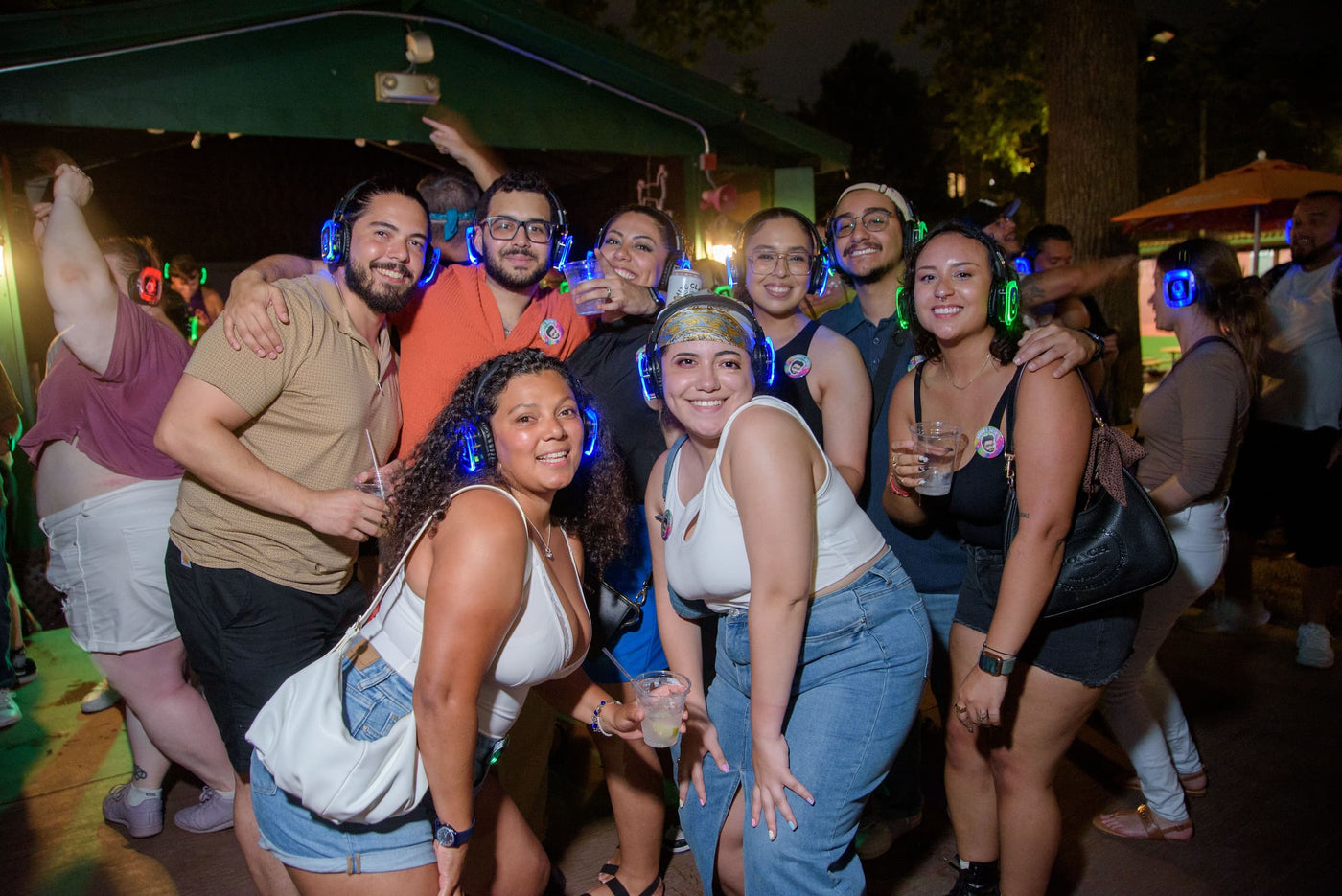 Quiet Events Silent Disco headphones for camps.  A group of people together having fun posing for a picture with headphones.
