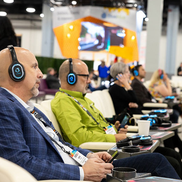 Quiet Events Silent Disco headphones for corporate gatherings a group of executives with headphones listening to a speaker