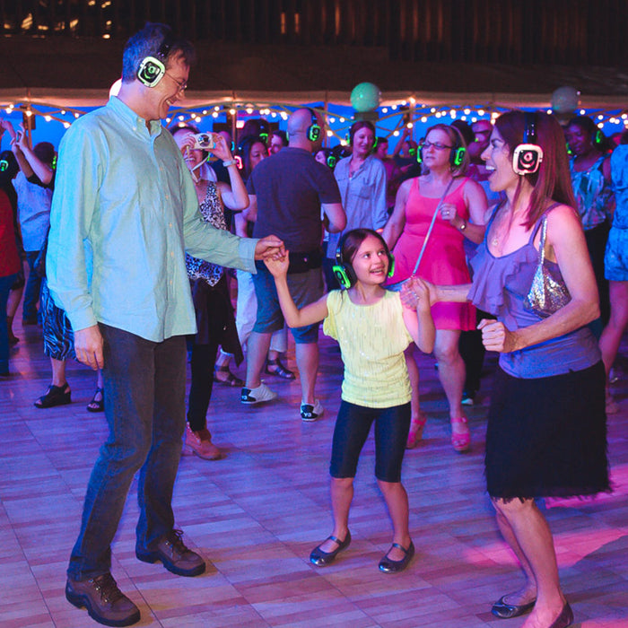 Quiet Events Silent Disco headphones for dance parties a family of three dancing having fun and listening to music.