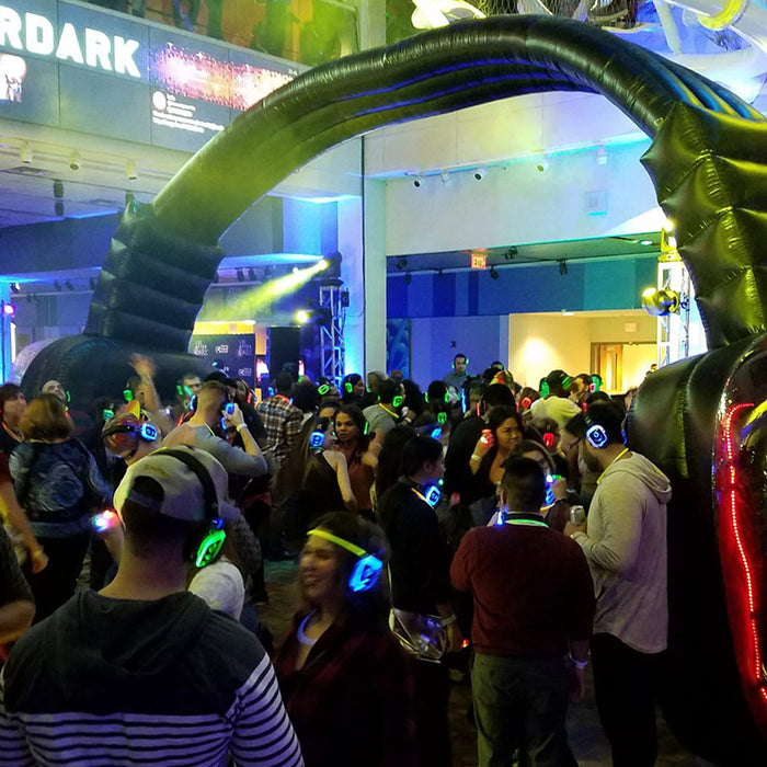 Quiet Events Silent Disco headphones for dance parties a group of people having fun listening to music with headphones on a dance floor