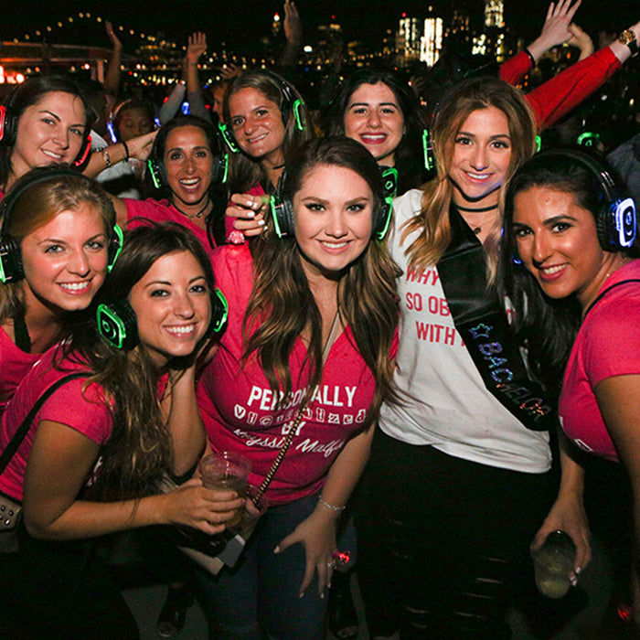 Quiet Events Silent Disco headphones for dance parties a group of girls celebrating a Bachelorette party at night with headphones.