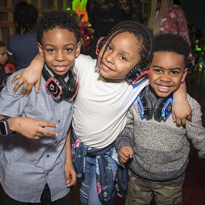 Quiet Events Silent Disco headphones for dance parties a group of three african american kids with headphones having fun.