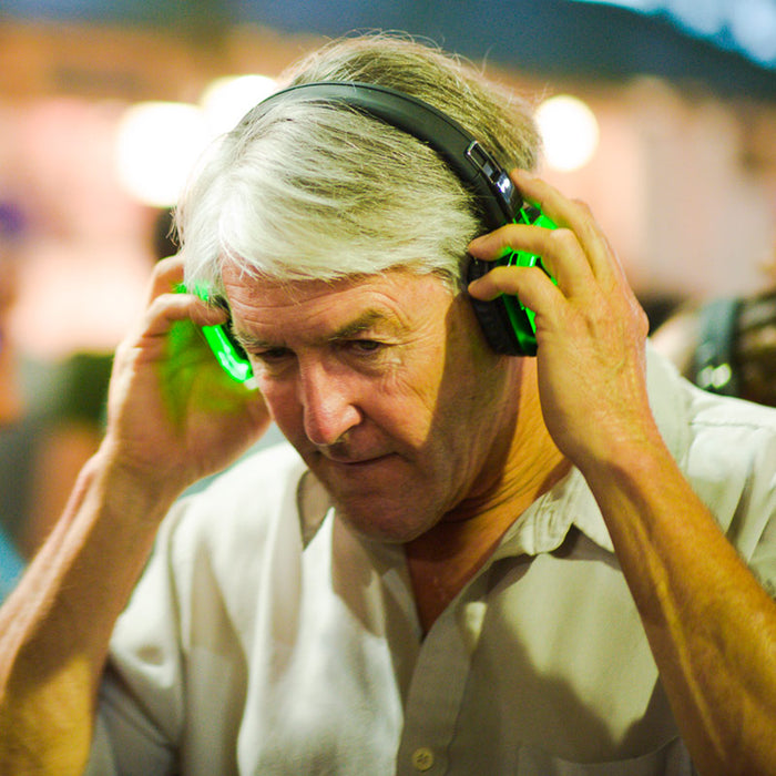 Quiet Events Silent Disco headphones for dance parties an older gentleman listening to music with his headphones on